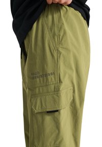 Grüne Cargo-Hose aus leichtem Stoff mit lockerem Schnitt. Eigenschaften sind Seitentaschen und bedruckte Textdetails.