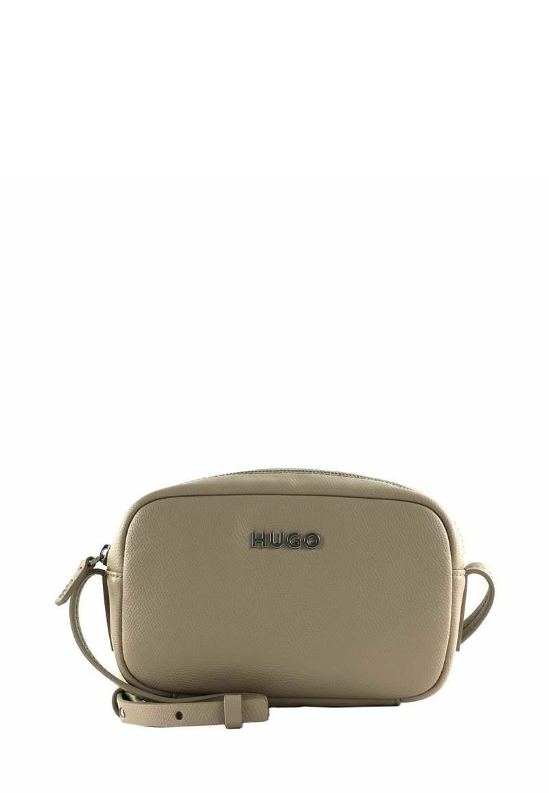 Beige Lederhandtasche mit abgerundeter Form, ausgestattet mit einem Reißverschluss und einem abnehmbaren Riemen. Auf der Vorderseite befindet sich ein Metall-Logo mit der Aufschrift "HUGO".