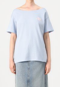 Světle modré bavlněné tričko s širokým výstřihem a krátkými rukávy. Na hrudi je pastely grafika s textem "PARADISE".