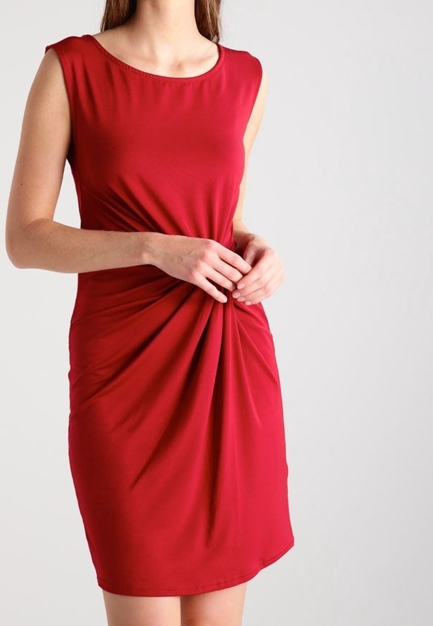 Röd ärmlös klänning med rund halsringning, tillverkad av ett slätt tyg, med en vriden framdesign och en figurnära siluett.