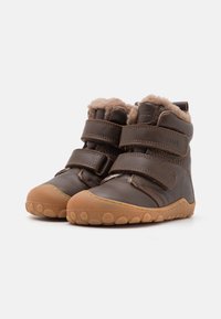 Stivaletti in pelle marrone con morbido rivestimento in pelliccia, dotati di due cinturini in velcro e suola in gomma con un motivo a pois.