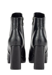 Botas de tobillo de cuero sintético negro con una textura suave, tacones altos de bloque y cremalleras laterales, que presentan un diseño simple y elegante.