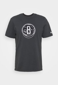 T-shirt en coton gris foncé avec un graphique blanc représentant un ballon de basketball avec la lettre "B" à l'intérieur, manches courtes et col rond.