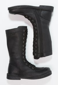 Bottes de combat en cuir noir avec un design montantes jusqu'aux genoux, présentant des lacets, une fermeture éclair sur le côté et un motif texturé sur la semelle et la tige.