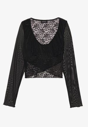 Svart långärmad topp med spetsöverdrag och texturerade meshärmar, med en djup V-ringning och lagerdesignförsköningar.