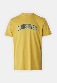 Yellow cotton t-shirt featuring "QUIKSILVER" in dark green arc text across the chest. Round neck, short sleeves, and regular fit.