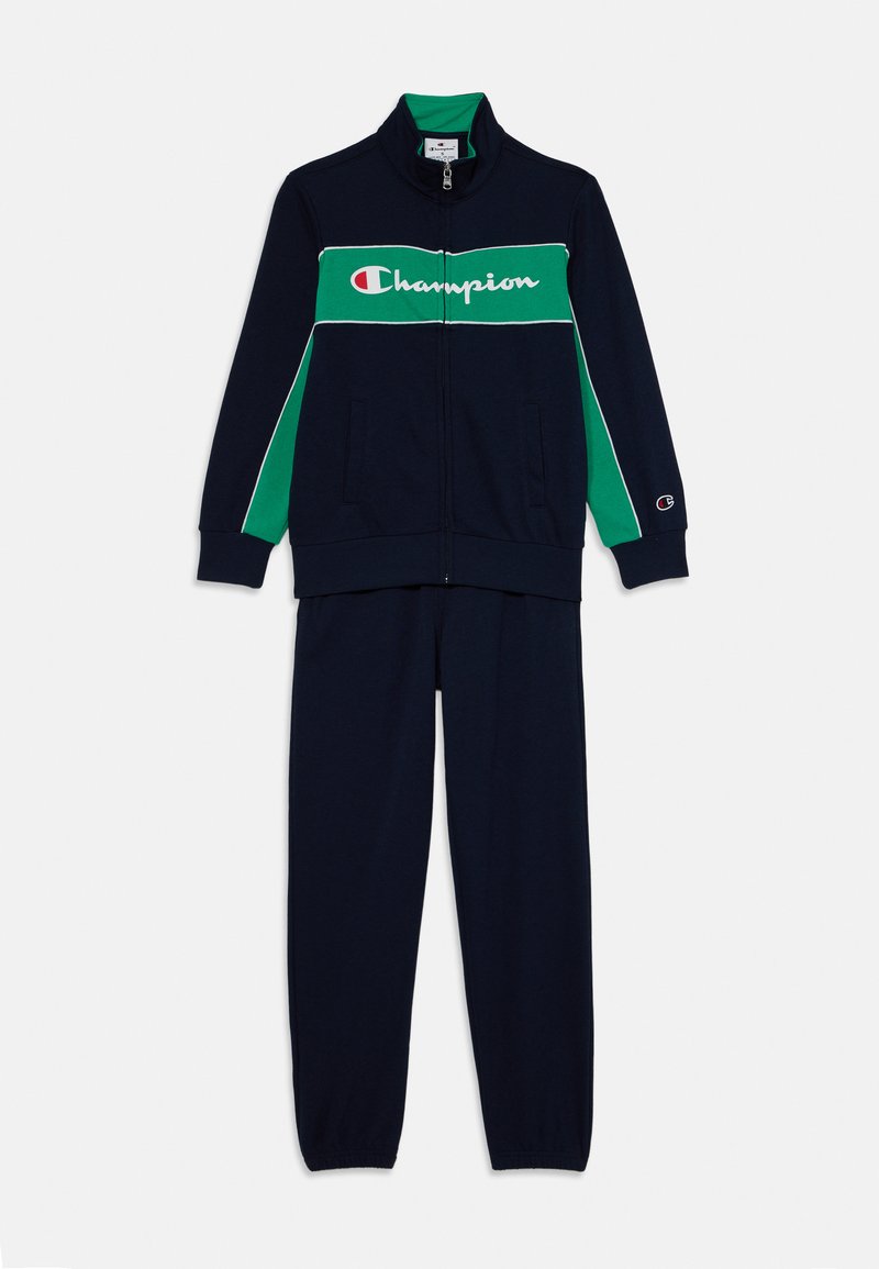 Námornícky modrý trackovací súbor obsahujúci bundu na zips s horizontálnymi zelenými a bielymi akcentmi a zodpovedajúce nohavice, vyrobené z mäkkej tkaniny.