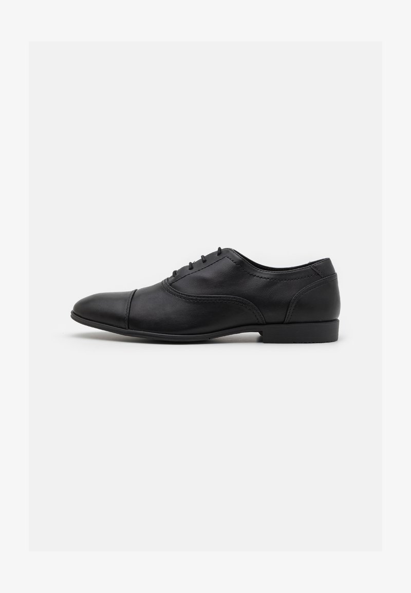 Black leather oxford shoe with a rounded toe, featuring a smooth finish, decorative stitching, and a low profile rubber sole.