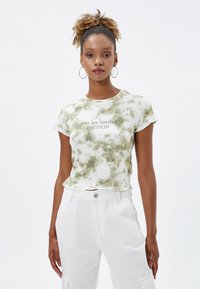 Korte mouwen, cropped t-shirt in groene tie-dye patroon met de tekst "you are limited EDITION". Gemaakt van zacht materiaal met een relaxte pasvorm.