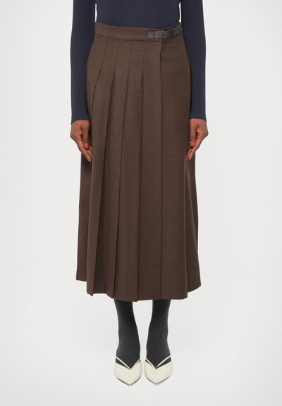 Brown pleated midi skirt with a side buckle detail, paired with dark gray socks and two-tone pointed-toe heels.