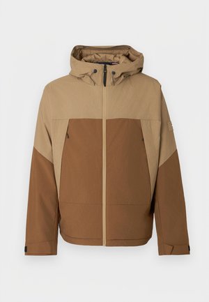 Veste bicolore marron en tissu texturé. Elle comporte une capuche, une fermeture éclair sur le devant, des poches latérales et des poignets réglables.