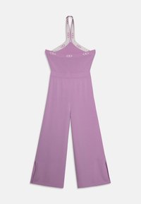 Salopette viola lavorata a maglia con ampie aperture per le gambe, design senza spalline e spalline regolabili con logo stampato. Materiale morbido e testurizzato.