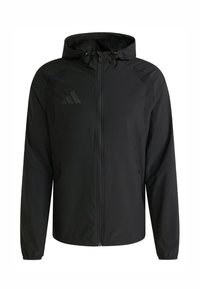 Chaqueta ligera negra con cremallera frontal, capucha ajustable y paneles laterales. Presenta un logo sutil en el pecho y puños elásticos.