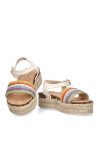 Sandalias espadrilles con suela de yute, que cuentan con correas sintéticas blancas y bandas tejidas multicolor en rojo, amarillo, verde y azul.