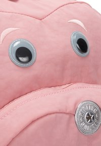 Zaino rosa con occhi lucidi neri e grigi. Presenta un tessuto testurizzato, rifiniture cucite e un pulsante rotondo argentato con un design a stella.
