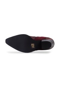 Chaussure en daim bourgogne avec un bout pointu et un petit talon noir. Tige texturée avec une semelle en caoutchouc noir lisse. Détail de marque doré sur la semelle.