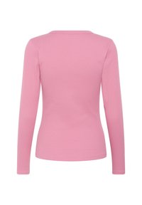 Hosszú ujjú, bordázott felső világos rózsaszínben. Kerek nyakkivágással és testhezálló szabással rendelkezik. Anyaga puhanak és rugalmasnak tűnik, sima felülettel.