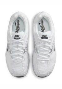 Tenisky Nike Moto 2K, s převážně bílým síťovým svrškem, stříbrnými akcenty, zaobleným tvarem a standardním šněrováním.