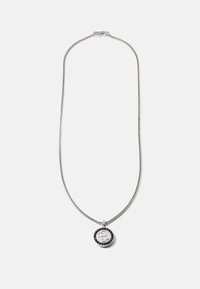 Colar de corrente em prata com um pendente circular apresentando um logótipo, rodeado por uma borda de acento preta. Textura suave e acabamento polido.