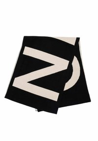 Czarny i kremowy ręcznik z odważnymi, geometrycznymi wzorami: dużym "M" i okrągłym kształtem. Miękka, teksturowana tkanina o gładkim wykończeniu.