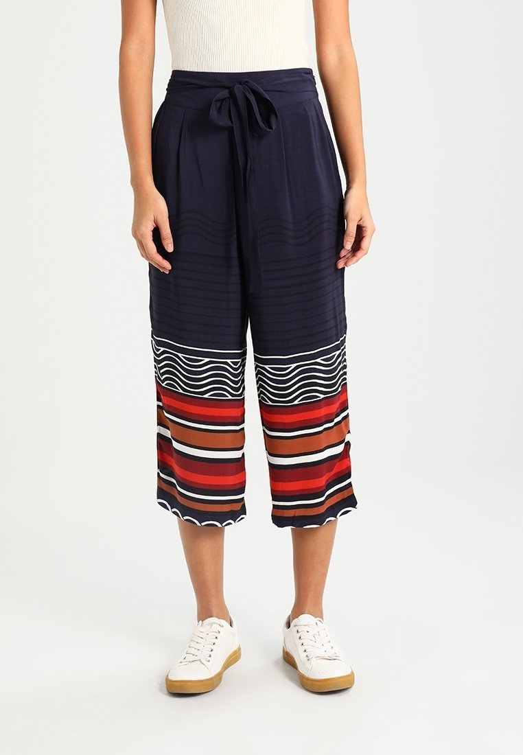 Marina culotter i lätt material med knytmidja. Har mönstrade ränder i röd, brun och vit vid fållen.