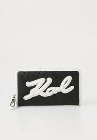 Black textured wallet featuring a white raised logo "Karl" on the front, with a zip closure and white accents along the edges.