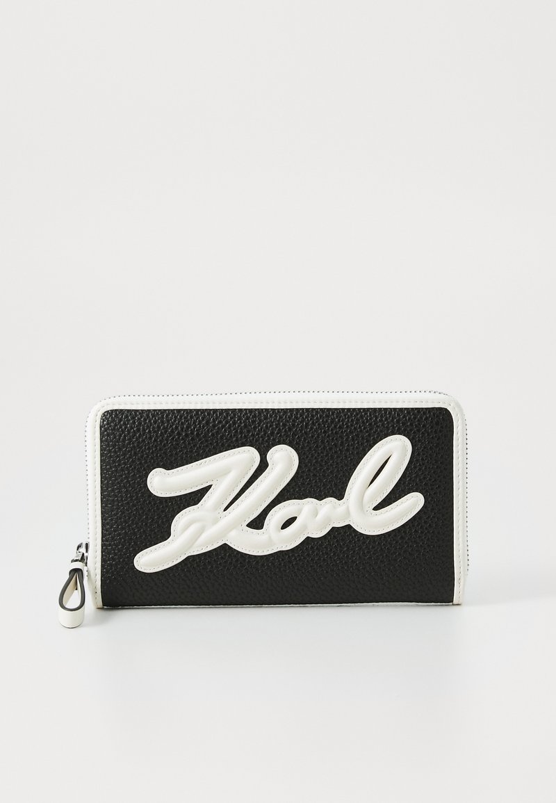 Black textured wallet featuring a white raised logo "Karl" on the front, with a zip closure and white accents along the edges.