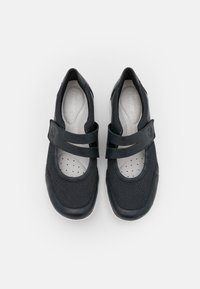 Black slip-on shoes with a mesh upper and solid toe cap. Features a broad strap over the vamp and padded insole with ventilation holes.