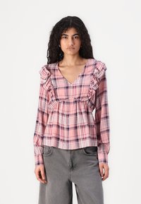 Pink plaid long-sleeve blouse with ruffled edges, V-neckline, and gathered waist. Features a mix of dark blue and white lines.