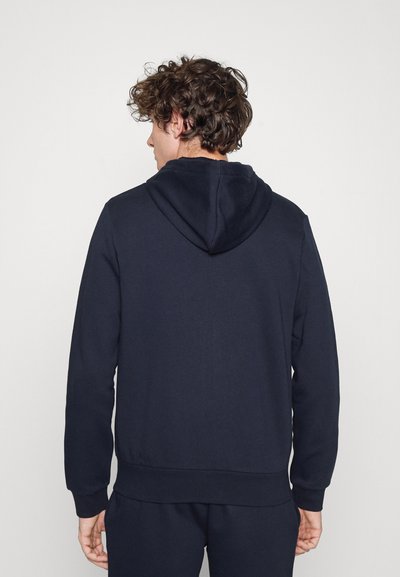 Sweatshirt bleu marine avec capuche, doté d'une texture lisse, de manches longues et d'un ourlet côtelé. Design simple, sans logos ni motifs visibles.
