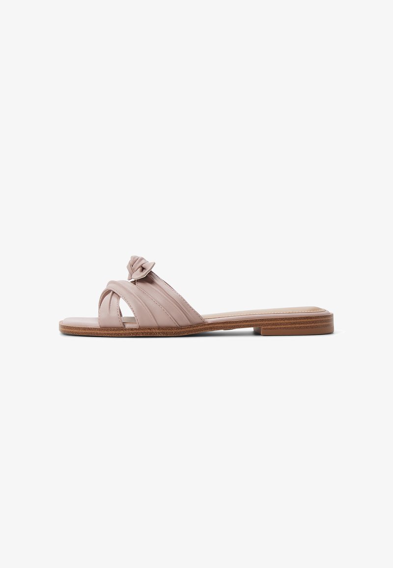 Slide sandal in soft pink leather, featuring a twisted strap design and flat sole with a subtle textured finish.