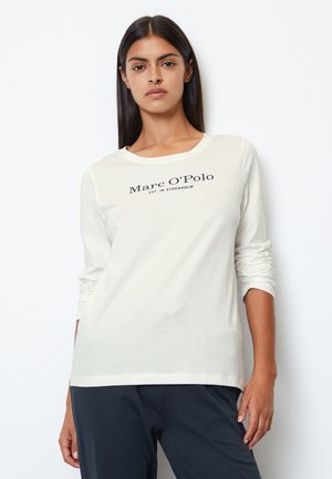 Camicia a maniche lunghe color crema realizzata in tessuto morbido, con scollo tondo e logo testuale scuro "Marc O'Polo" con "EST. IN STOCKHOLM."