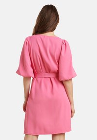 Rosa Kleid mit Puffärmel und Taillenband. Glattes Material, knielang, mit rundem Ausschnitt und gefalteten Rückendetails.