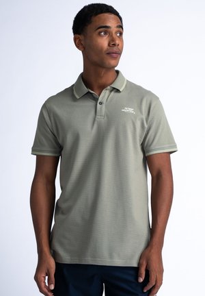 Green polo shirt with short sleeves, textured fabric, contrast collar and sleeve trim, featuring white logo on the chest.
