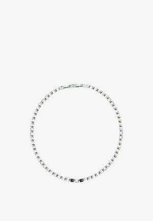 Collier de tennis en argent avec une pierre carrée claire et deux pierres noires au centre, présenté sur fond blanc.