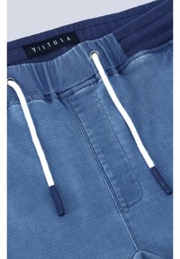 Pantalones cortos de mezclilla azul con una banda elástica de navy acanalada, cordones blancos y ojales de metal. Presenta costuras visibles y una etiqueta de marca.