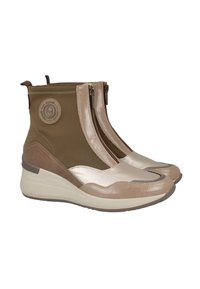 Zapatillas cuña de altura media en marrón claro y beige, con cremallera frontal, parche de logo redondo en el lateral y una combinación de materiales de cuero y tela.