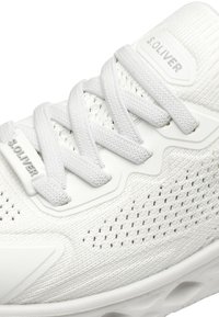 Chaussure de sport blanche avec une tige en textile respirant, des lacets épais et un design simple. Détail de logo remarquable sur le côté et semelle texturée.