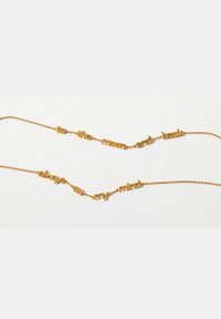 Guldtonet halskæde med sammenkædede bogstaver, der staver "til månen og tilbage" og "altid i mine tanker", med en fin kæde og et legende design.