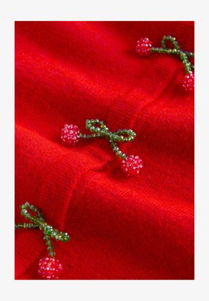 Crvena vunena tkanina s zelenim perlicama u obliku mašnica i malih cvjetova s sjajnom teksturom, koja dodaje dekorativne detalje.
