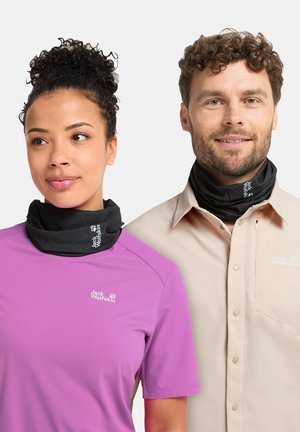 Een man en vrouw dragen zwarte nekwarmers en Jack Wolfskin topjes; zij in roze korte mouwen, hij in beige lange mouwen.