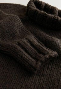 Dark brown knitted sweater with a ribbed turtleneck and textured fabric, featuring chunky stitches and a soft, thick appearance.