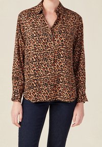 Leopardmönstrad skjorta med knappar i brunt och svart med röda accenter, långa ärmar och klassisk krage. Slät tyg med avspänt snitt.