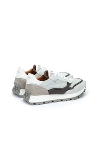 Zapatillas de cordones con parte superior de malla blanca, acentos de ante gris, detalles de cuero marrón y suela de goma gris gruesa.