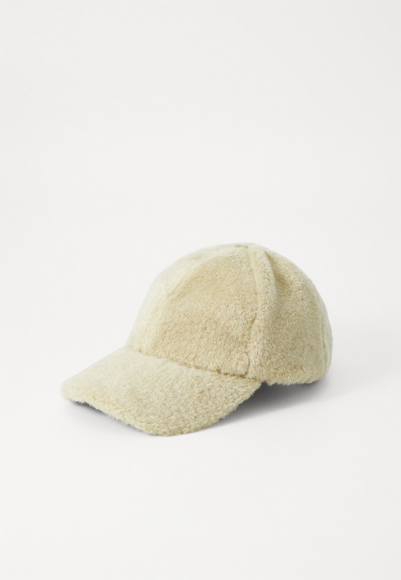 Căciulă de baseball bej pufoasă, cu o margine curbată, dintr-un material texturat și cu un design din șase panouri, având o strălucire subtilă și fără logo-uri vizibile.