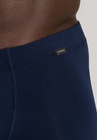 Námořnické modré boxerky vyrobené z měkkého materiálu s plochým pasem. Na přední straně poblíž švu pasu se nachází černá značka s nápisem "HANRO".