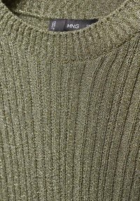 Grüner gerippter Pullover mit strukturiertem Strick, rundem Ausschnitt und dezenten metallischen Fäden. Etikett zeigt "MNG, hergestellt in der Türkei."