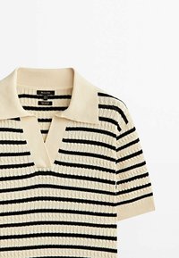 Pull court à manches courtes en maille crème avec des rayures horizontales noires, doté d'un col polo et d'un motif texturé sur l'ensemble.