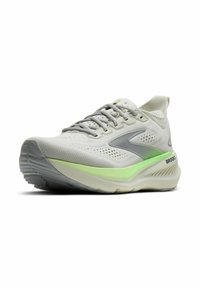 Witte en grijze sportschoen met lichtgroene middenzoolaccent en Brooks-logo op de hiel, schuin geplaatst om de voorkant en zijkant te tonen.