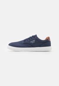 Navy canvas sneakers with white rubber sole, round toe, six eyelets, and brown accents on the heel. Features logo on the side.